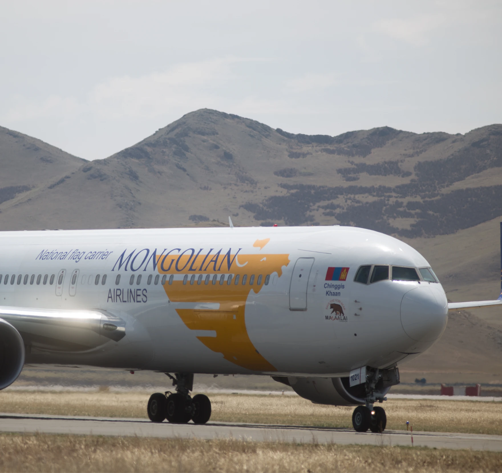 Mongolian airlines plane with hills in the back