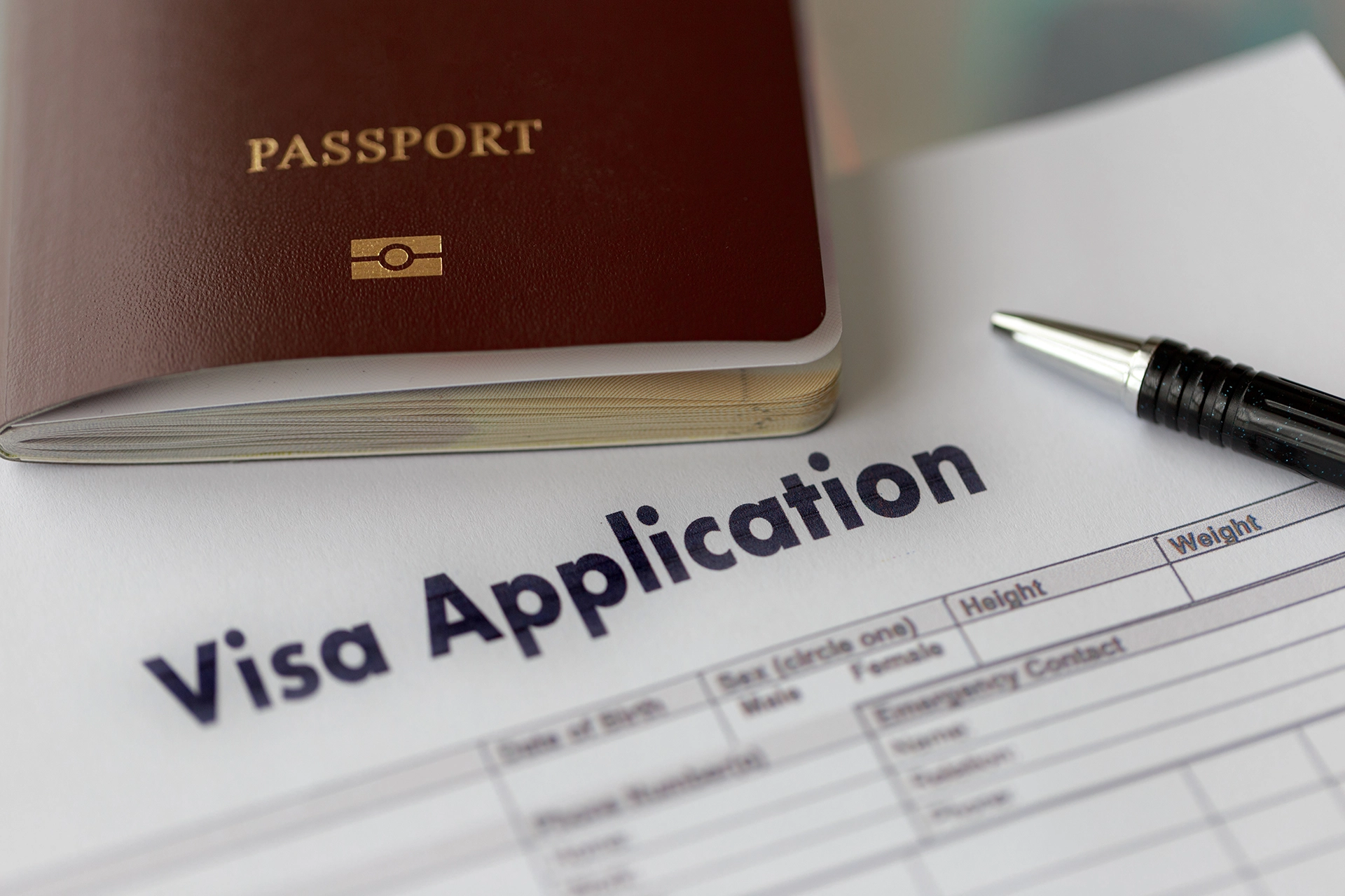 Visa application form with a passport and a pen